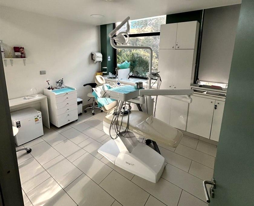 Box de atención de Clínica LEMA con sillón dental y ventana al exterior