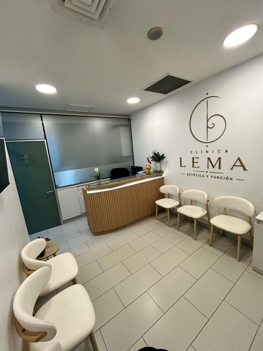 Recepción de Clínica LEMA con el logo en la pared y sillas de espera
