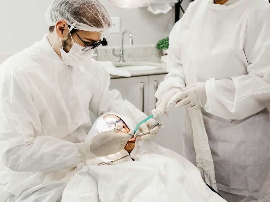 Cirujano dentista realizando un procedimiento con su asistente